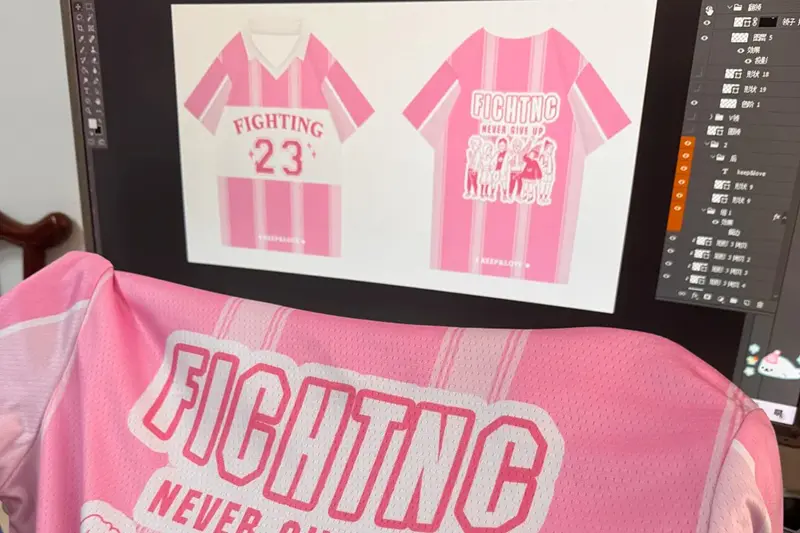 Pink number 23 team jersey held in front of its front and back artwork