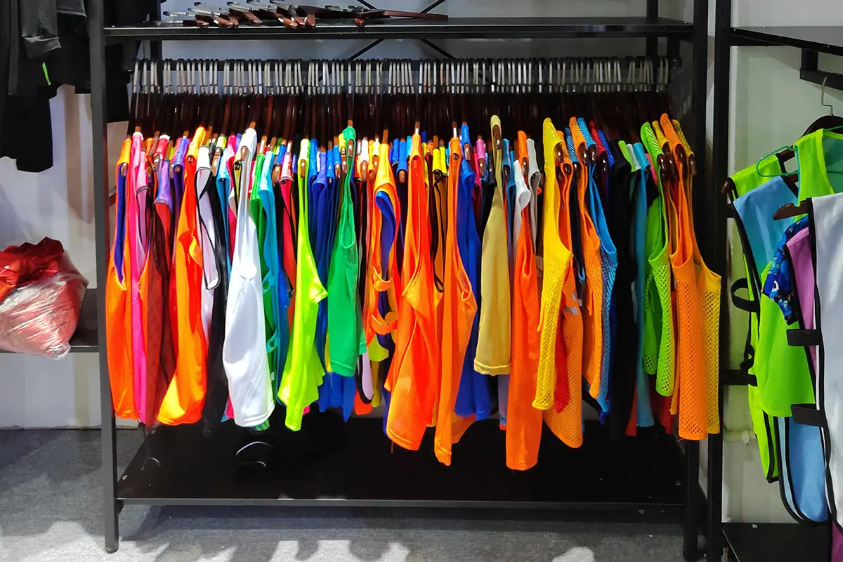 Bright mesh training tops hanging on a sample rack