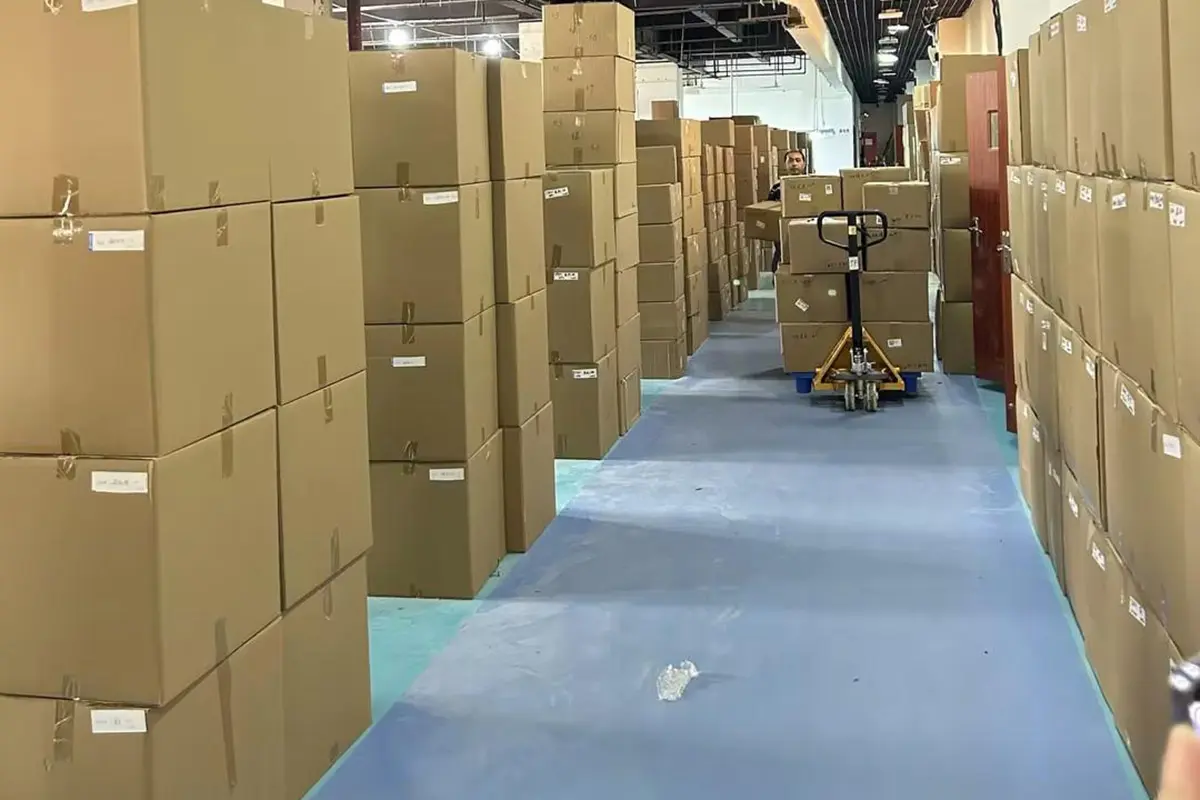 Packed cartons stacked along the factory dispatch aisle