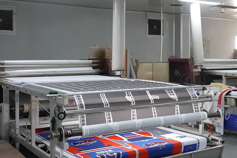 Printed jersey panels passing through a roll heat press