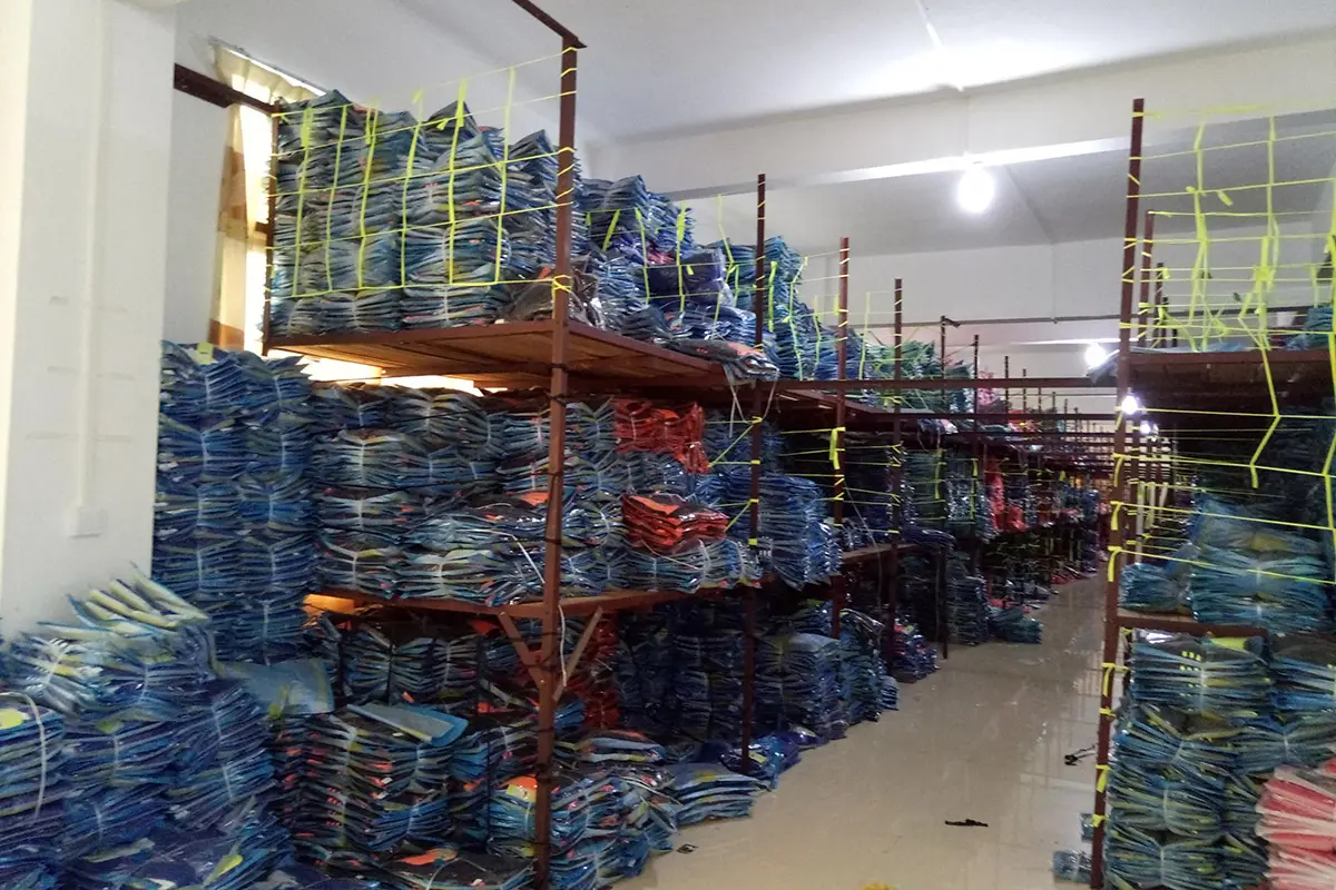 Packed jerseys grouped on warehouse racks by batch