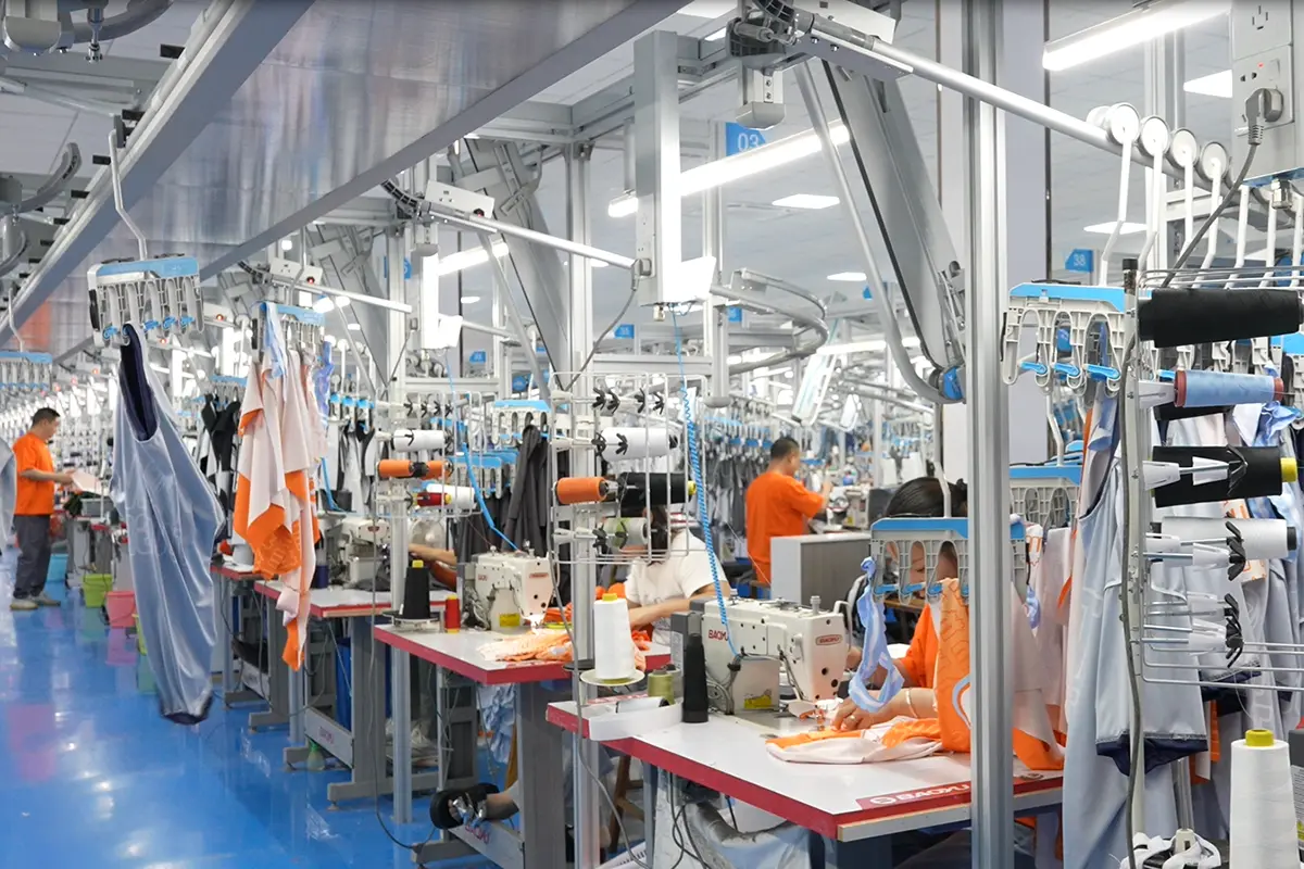 Workers sewing custom jerseys across the production floor