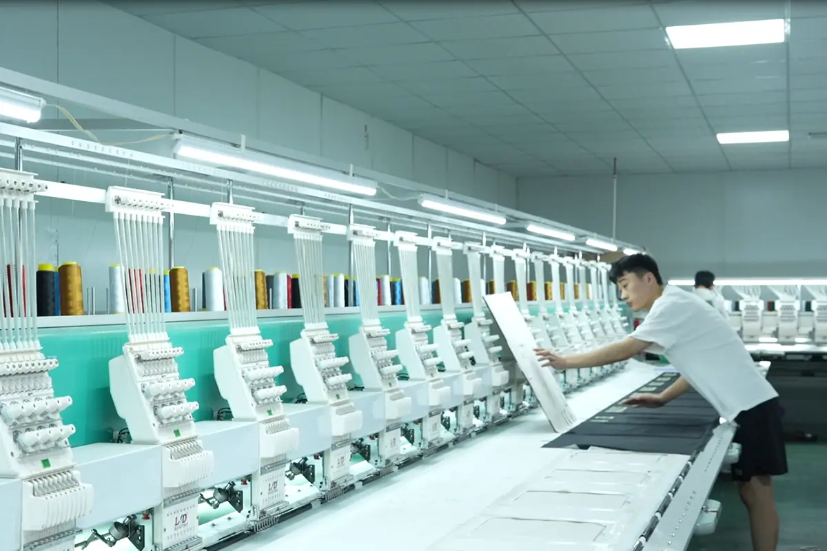 Worker setting up fabric on a multihead embroidery machine