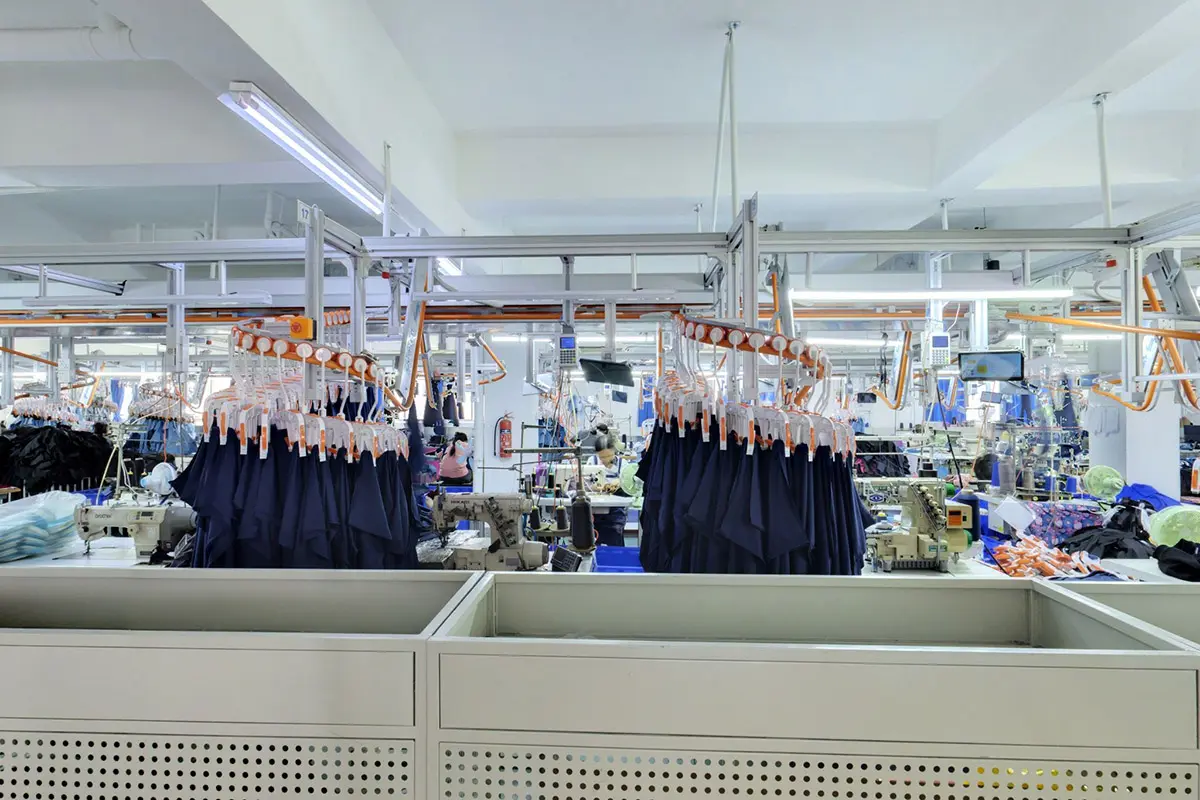 Dark jersey panels organized above a factory production line