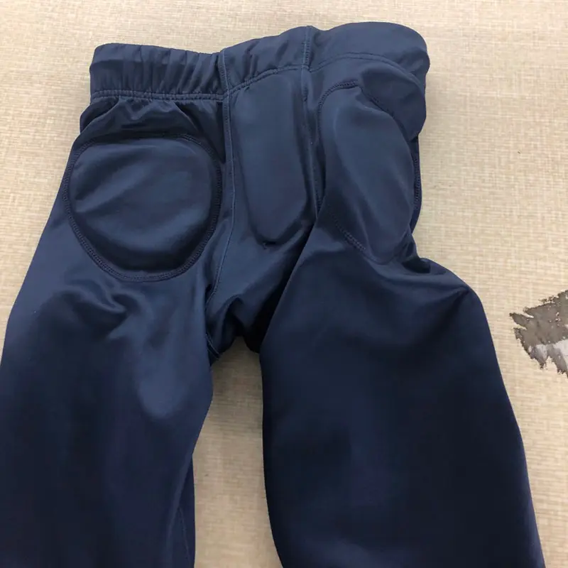 Navy padded American football pants showing hip and thigh pads