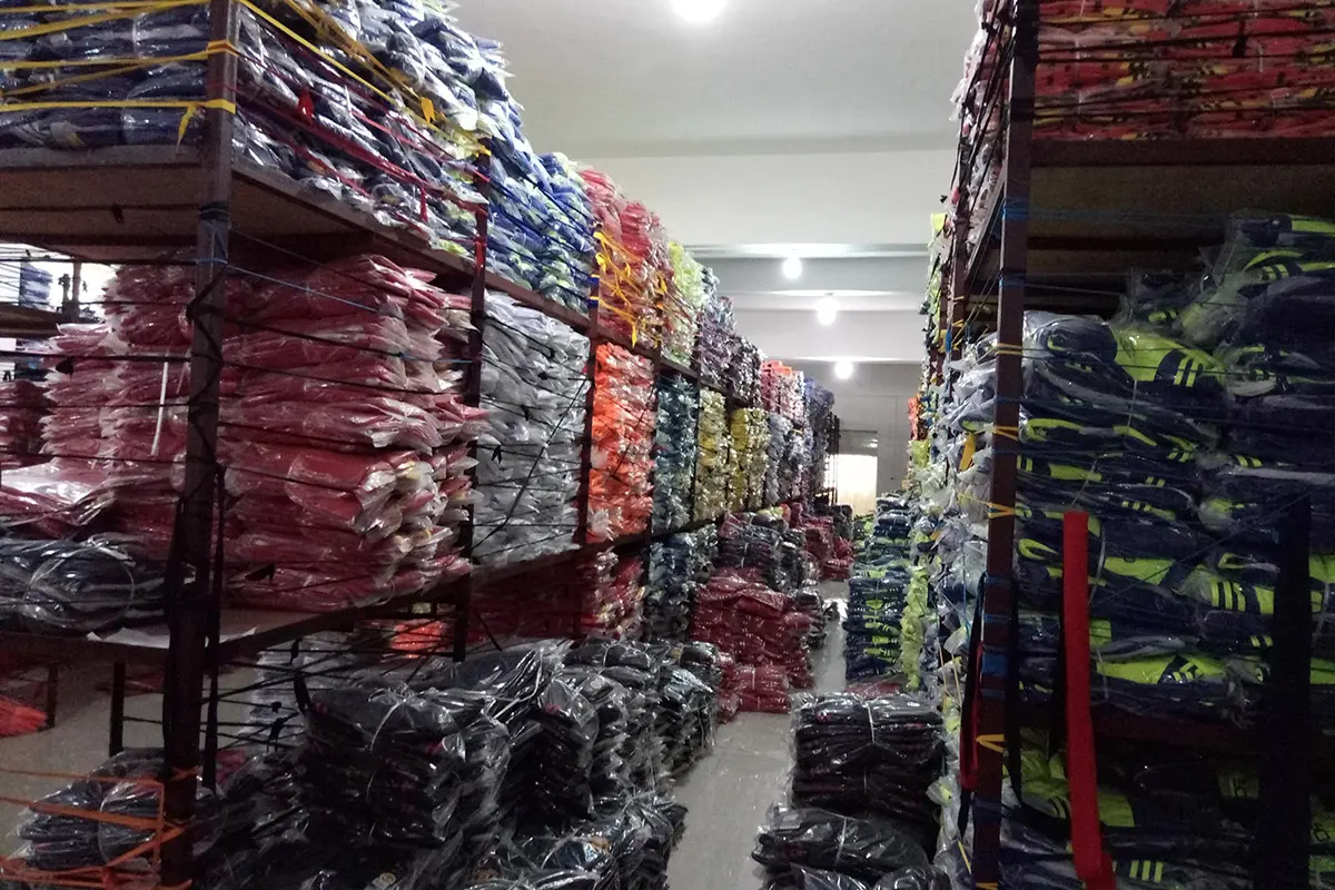 Packed teamwear grouped by color on storage racks