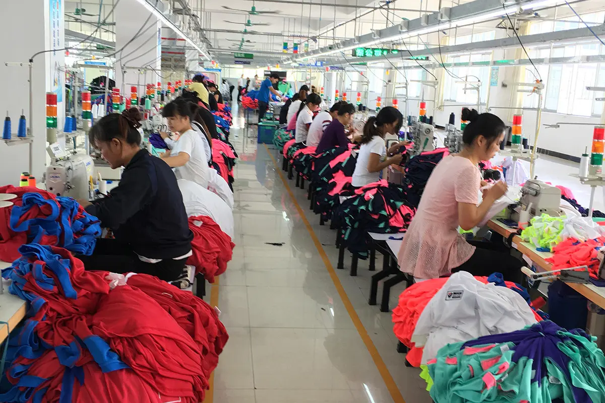 Workers sewing jerseys sorted in bright color batches
