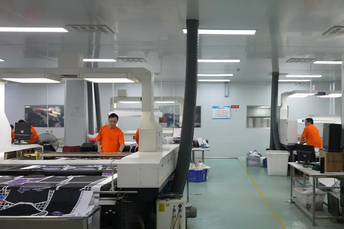 Operators working with printed jersey panels at flatbed heat presses