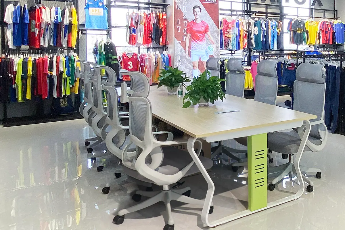 Meeting table beside racks of jersey samples