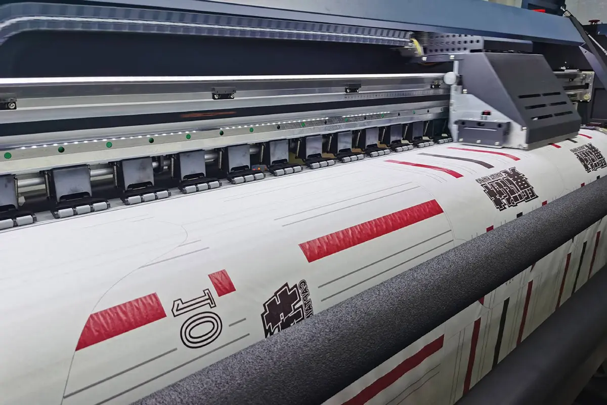 Custom jersey lettering and logos moving through a wide-format printer