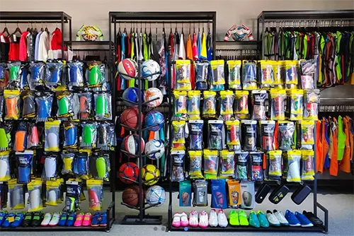 Sportswear, balls, shoes, and accessories arranged on display racks