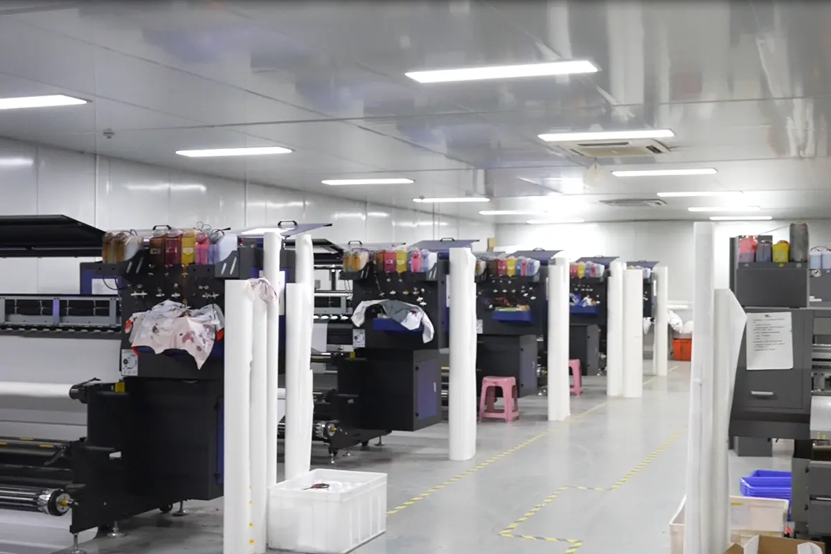 Wide-format printers with material rolls lined across the print room