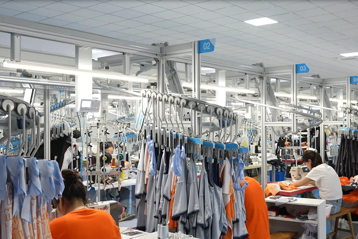 Sleeveless jersey pieces hanging between sewing stations