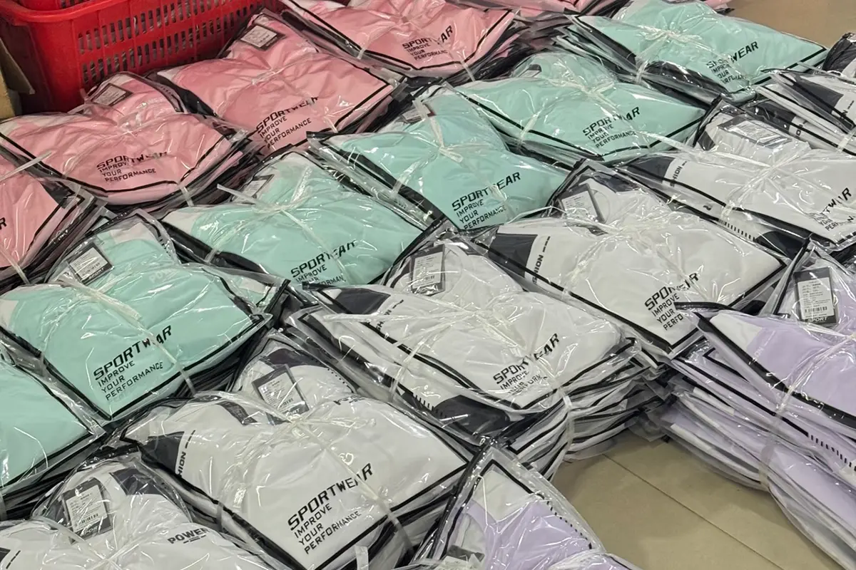 Pink, mint, white, and lavender teamwear packed in labeled clear bags