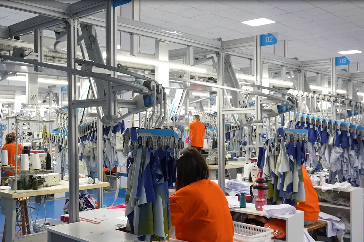 Workers sewing custom jerseys across a production line