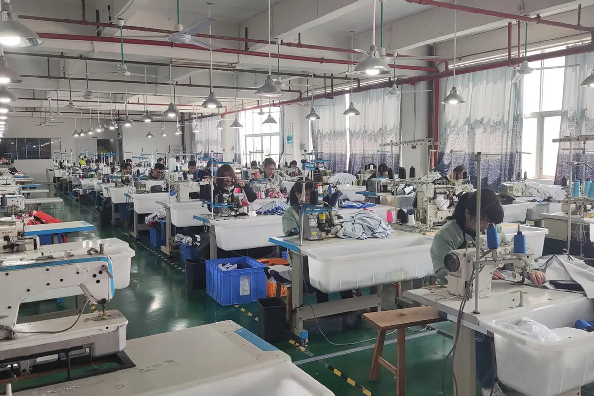 Operators sewing jerseys across a production workshop