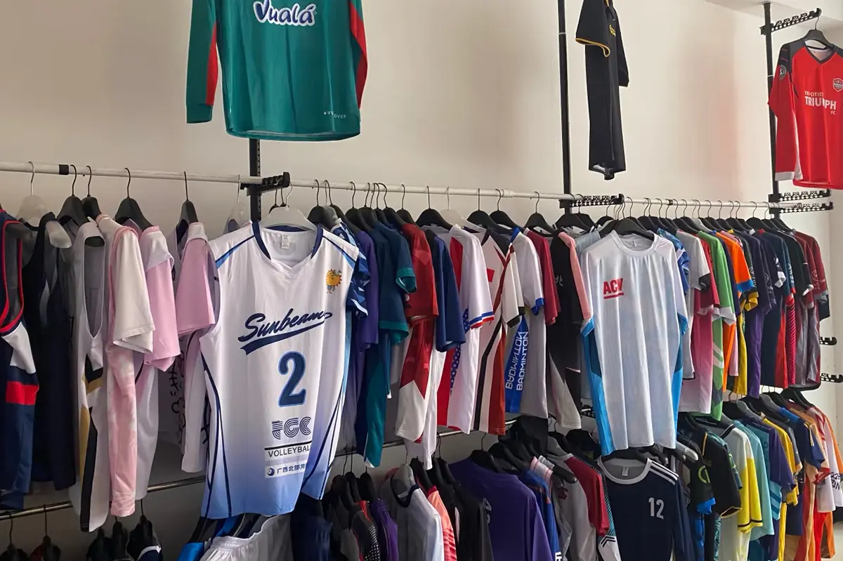 Volleyball and other team jersey samples displayed across showroom racks
