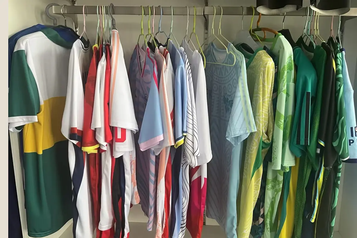 Custom team jerseys in different colors and sleeve styles hanging on a sample rack