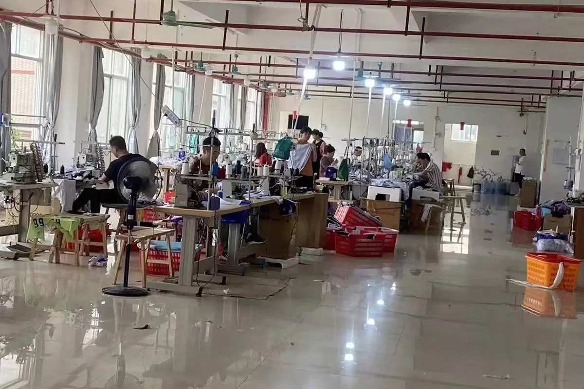 Workers sewing jerseys across a daylight production workshop
